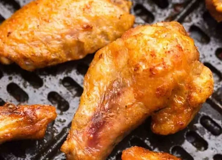Delicious air fryer frozen chicken wings cooking in a basket