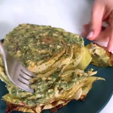 Cabbage steaks garnished with herb butter on a plate