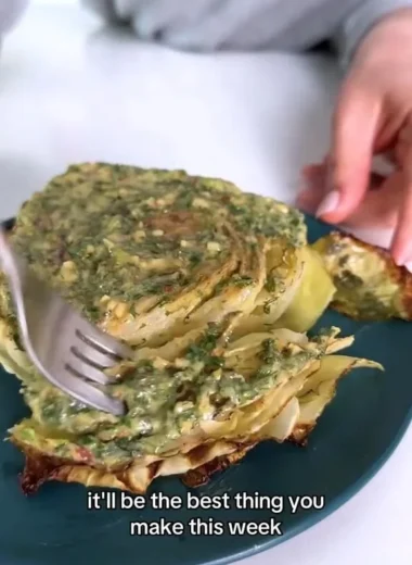 Cabbage steaks garnished with herb butter on a plate