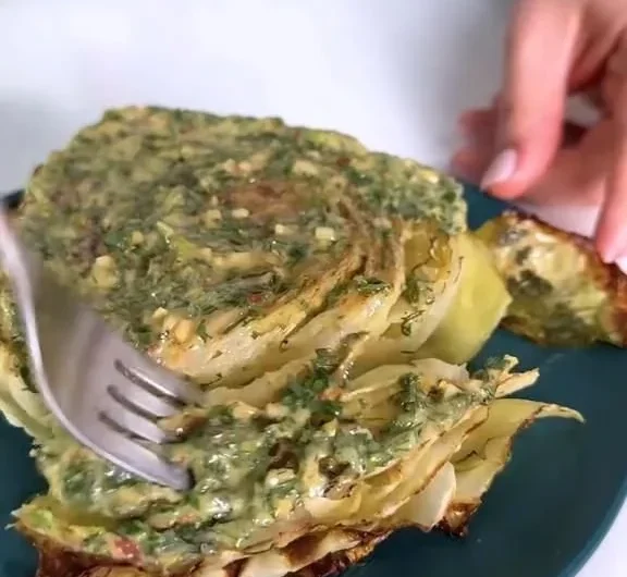 Cabbage steaks garnished with herb butter on a plate