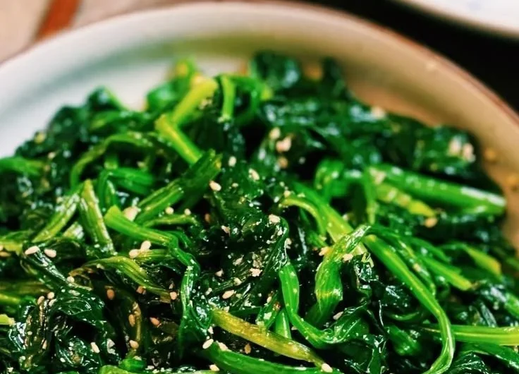Korean Spinach Salad (Sigeumchi Namul) served in a bowl with sesame seeds
