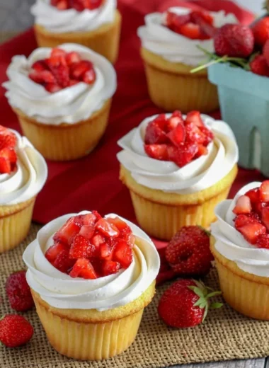 Delicious strawberry shortcake cupcakes topped with fresh strawberries and whipped cream