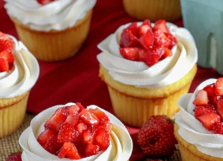 Delicious strawberry shortcake cupcakes topped with fresh strawberries and whipped cream