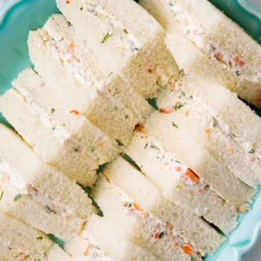 Veggie cream cheese finger sandwiches arranged on a platter for a party