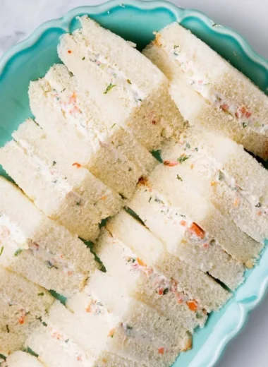 Veggie cream cheese finger sandwiches arranged on a platter for a party