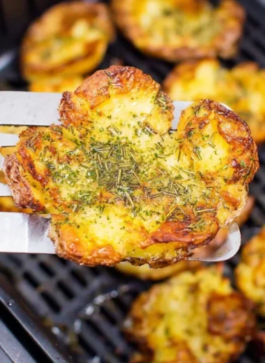 Crispy air fryer smashed potatoes garnished with herbs