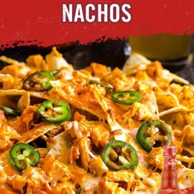 Delicious Buffalo Chicken Nachos topped with cheese and garnishes