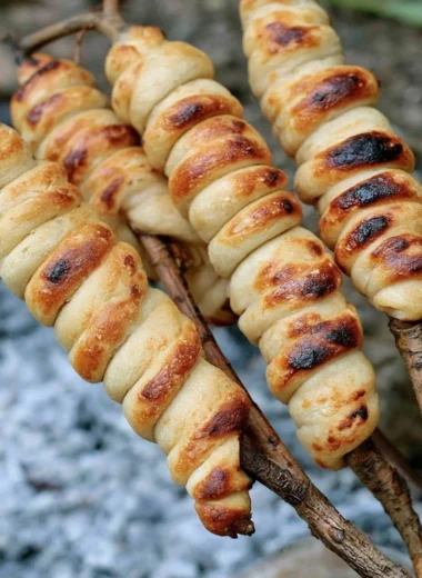 Homemade campfire bread cooking over an open flame