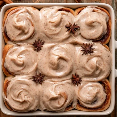Freshly baked chai cinnamon rolls with spices and icing on top