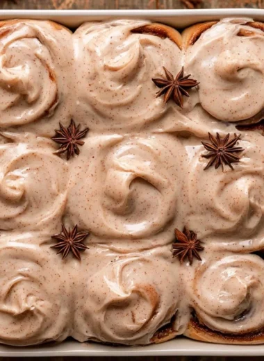 Freshly baked chai cinnamon rolls with spices and icing on top