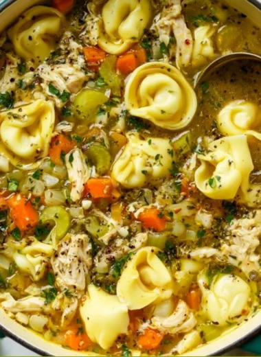 Delicious bowl of Chicken Tortellini Soup topped with herbs and ingredients