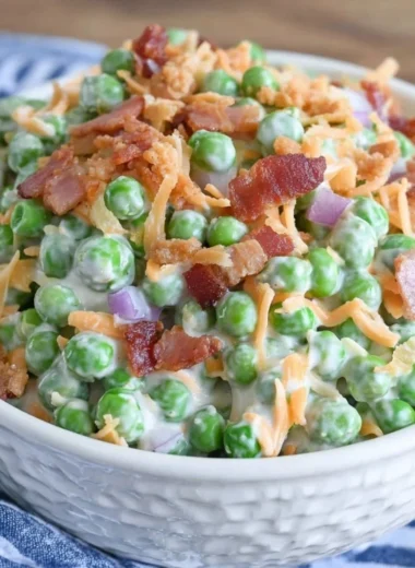 Bowl of classic pea salad with bacon, showcasing fresh peas and vibrant ingredients.