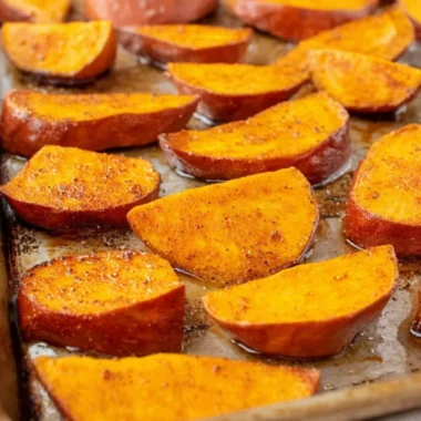 Bowl of easy roasted sweet potatoes garnished with herbs