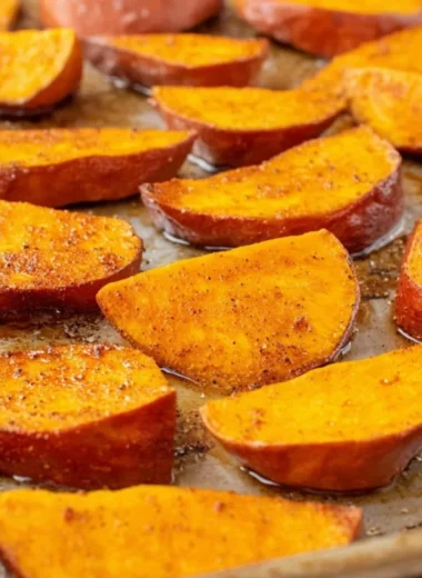 Bowl of easy roasted sweet potatoes garnished with herbs