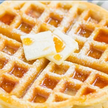 Delicious fluffy Belgian waffles topped with syrup and berries
