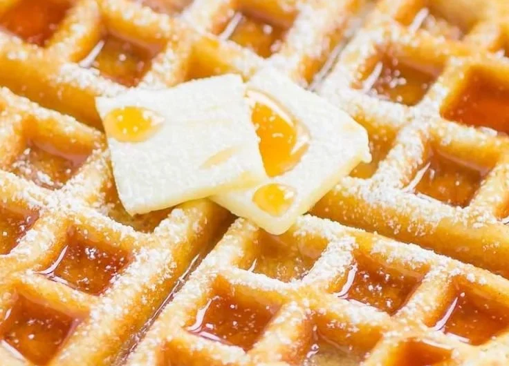 Delicious fluffy Belgian waffles topped with syrup and berries