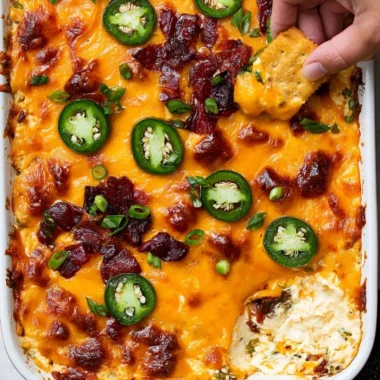 Creamy jalapeno popper dip served in a bowl, garnished with green onions.