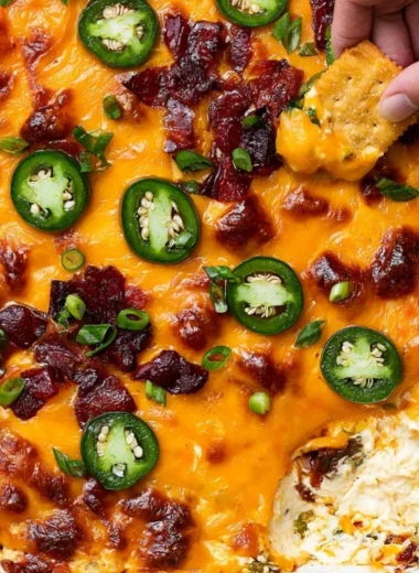 Creamy jalapeno popper dip served in a bowl, garnished with green onions.