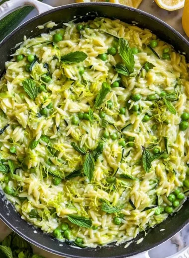 Delicious lemon orzo with zucchini on a plate garnished with herbs