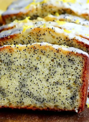 Moist lemon poppy seed bread sliced on a wooden board