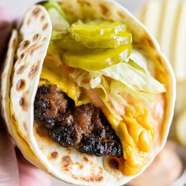 Delicious Smash Burger Taco topped with special burger sauce on a plate.