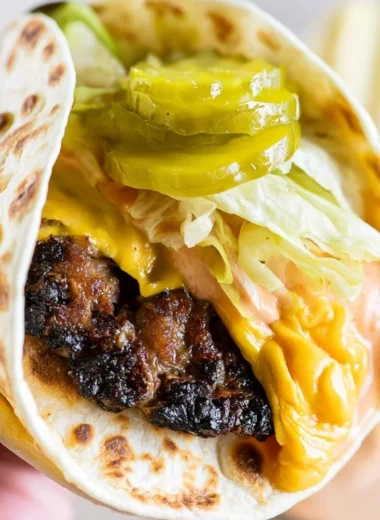 Delicious Smash Burger Taco topped with special burger sauce on a plate.
