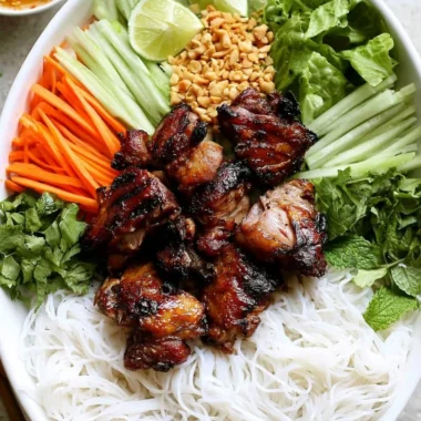 Vietnamese grilled pork rice noodle bowl garnished with fresh herbs and vegetables