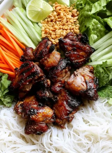 Vietnamese grilled pork rice noodle bowl garnished with fresh herbs and vegetables