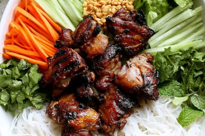 Vietnamese grilled pork rice noodle bowl garnished with fresh herbs and vegetables