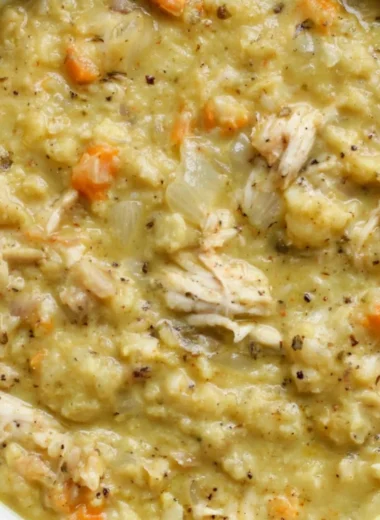 Bowl of anti-inflammatory cauliflower chicken soup garnished with herbs.