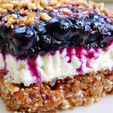 Delicious Blueberry Pretzel Salad with creamy topping and crunchy pretzel crust.