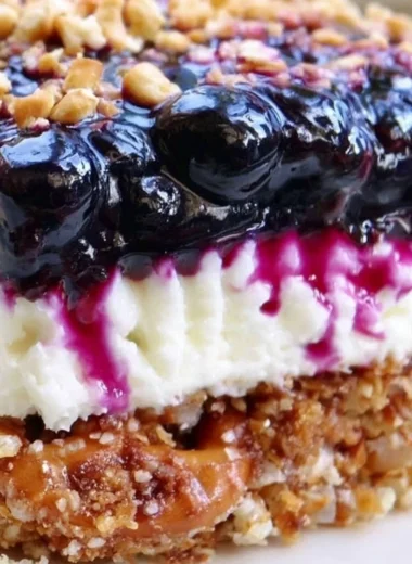 Delicious Blueberry Pretzel Salad with creamy topping and crunchy pretzel crust.