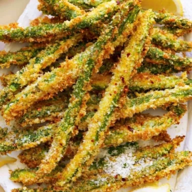 Crispy breaded air fryer asparagus on a plate.