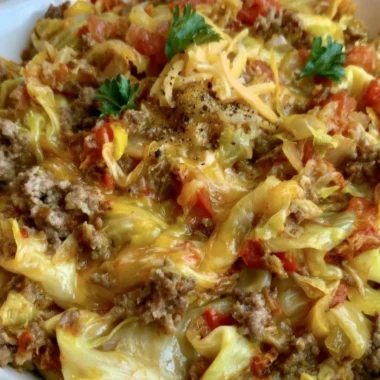 Cabbage Roll Skillet with savory filling and topped with cheese, served on a plate.