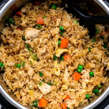 Delicious cozy Instant Pot chicken fried rice served in a bowl with vegetables.