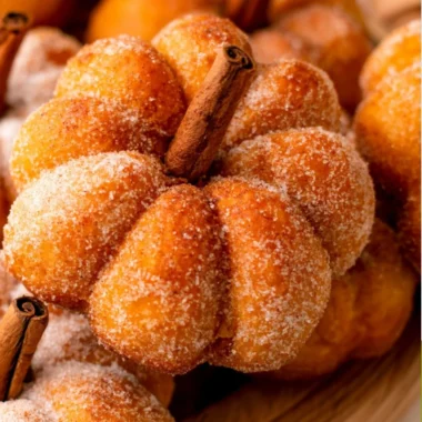Cozy pumpkin donuts on a wooden table with autumn decorations