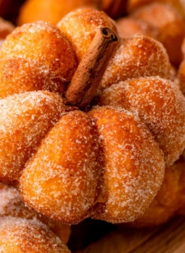 Cozy pumpkin donuts on a wooden table with autumn decorations