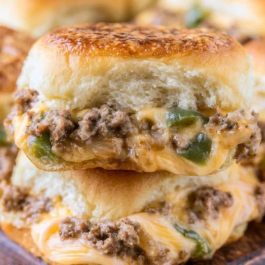 Philly Cheesesteak Sliders served with peppers and onions on a platter