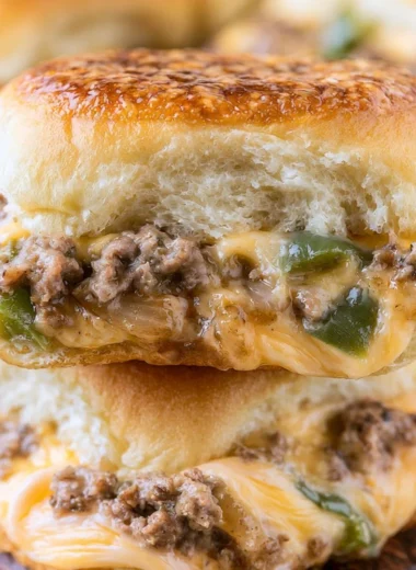 Philly Cheesesteak Sliders served with peppers and onions on a platter