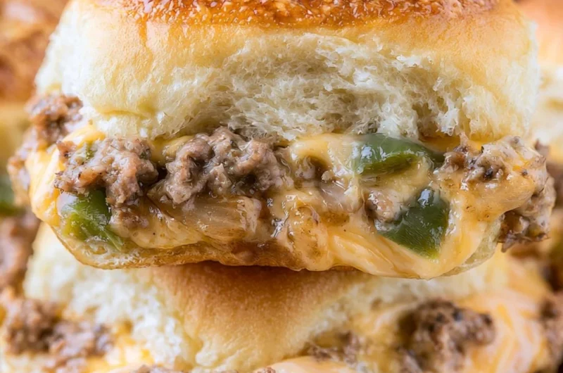 Philly Cheesesteak Sliders served with peppers and onions on a platter