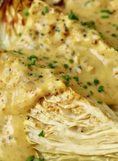 Roasted cabbage wedges served with onion-Dijon sauce on a plate