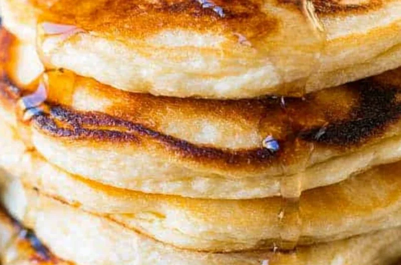 Fluffy ricotta pancakes topped with fresh berries and syrup on a plate.